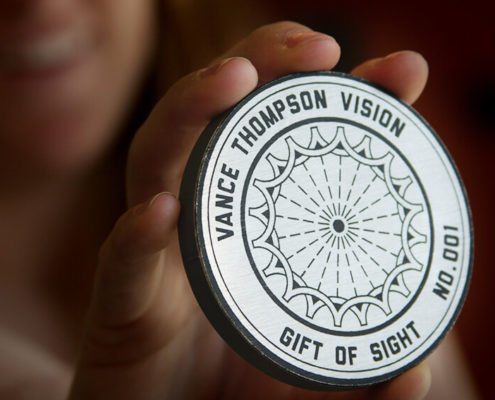 Woman holding Gift of Sight medallion